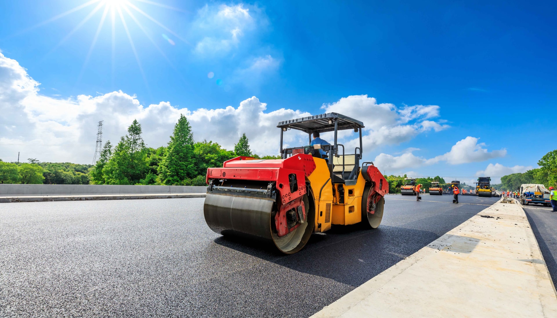 An asphalt contractor in Saint Paul, MN drives an asphalt roller on a construction site.